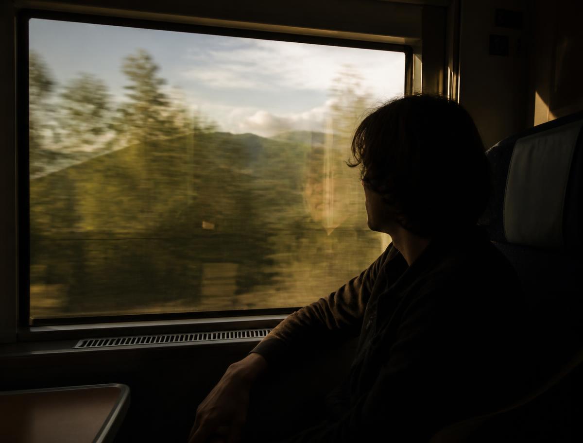 Viaggiatore guarda il paesaggio dal finestrino di un treno in movimento